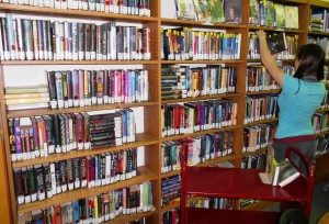 Student shelving in the YA section